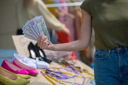 Successful day. Close up of one hundred dollar banknotes in female hand after the saleの写真素材