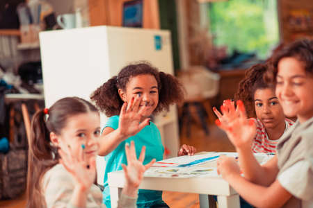 Stained but happy. Kids stained their fingers while painting with watercolorsの写真素材