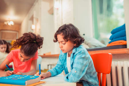 Elementary school. A concentrated boy solving math problems at classの写真素材