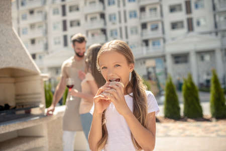 Tasty sandwich. Pretty girl eating sandwich and looking contentedの写真素材