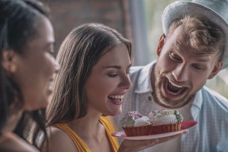 Delicious cakes. An excited woman holding a plate with cakes