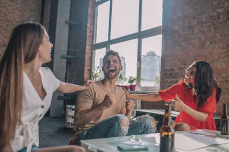 Expressing emotions. An emotional man enjoying playing a board game with friends
