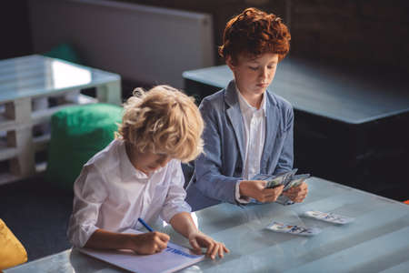 Savings. Two friends counting saved money and looking involved