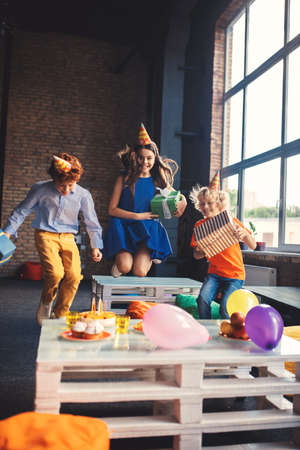 Fun time. Three friends in bday hats having fun togetherの写真素材