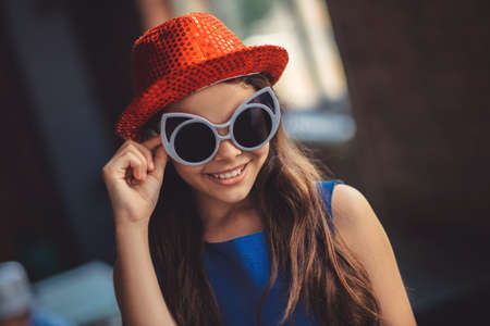 Fashionista. Pretty girl in eyeglasses and hat smiling nicelyの写真素材