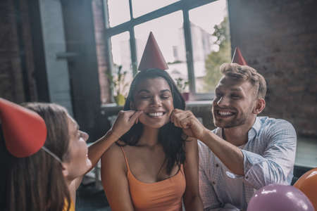 Happy birthday. Friends greeting a woman during the birthday partyの写真素材