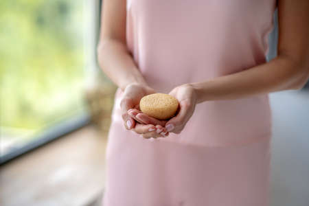 In the bathroom. Close up picture of womans hands with a yellow spongeの写真素材