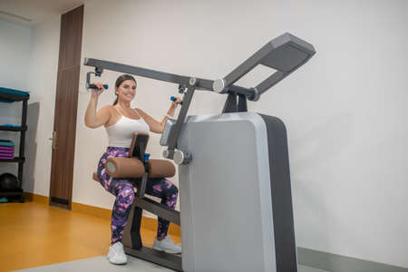 Healthy lifestyle. A woman training her hands muscles in a gym