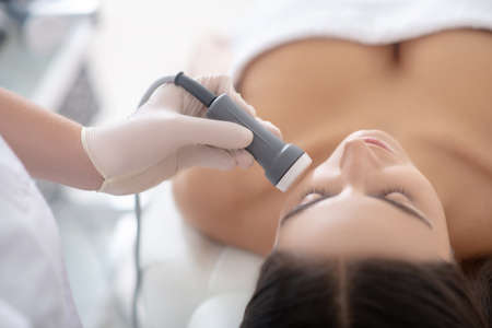 Face care. Young woman lying down during professional beauty procedures