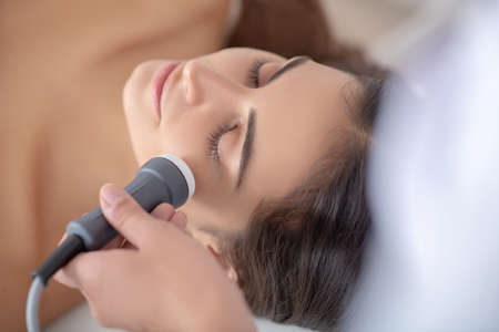 Face care. Young woman lying down while beauty proceduresの写真素材