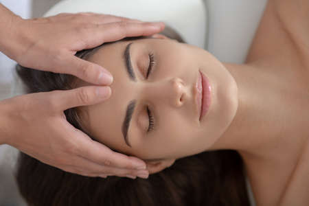 Face massage. Professional massage therapist massaging forehead of a woman
