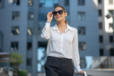 In the street. Beautiful dark-haired stylish woman walking down the streetの写真素材