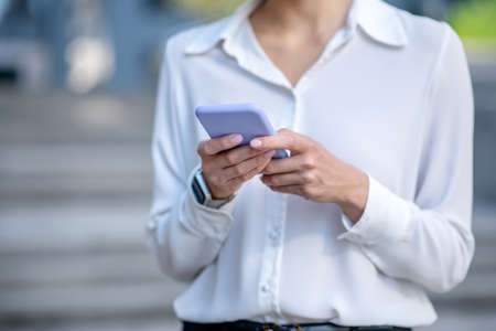 Gadget. Close up picture of a woman holding a smartphoneの写真素材