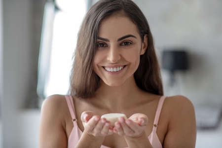 Spa procedures. A smiling young woman holding a piece of soapの写真素材