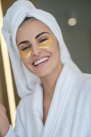 Spa day. Headshot of pretty smiling girl with eye patches