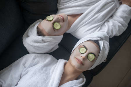 Harmony. Young women having face treatment and looking peacefulの写真素材