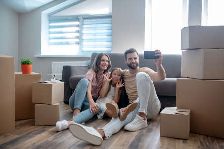 Happy moment. Happy family making photo and looking contented