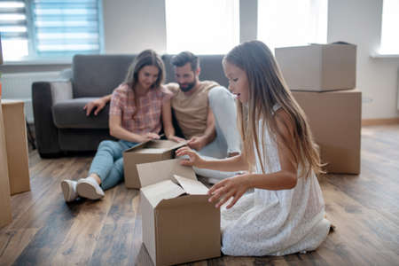 Unpacking. Family unpacking cardboards in a new house