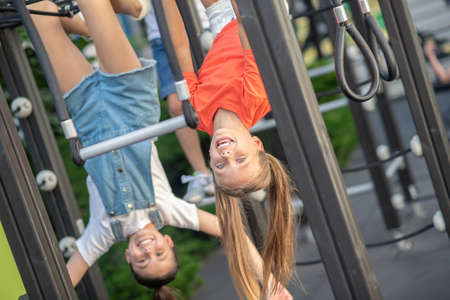 Head down. Girls hanging on playground with their heads down