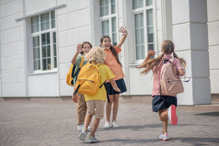Friends. Schoolchildren meeting after lessons in school yard and feeling goodの写真素材
