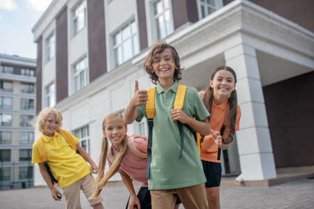 Happy kids. Schoolchildren playing in school yard and looking cheerfulの写真素材