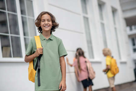 Happy. Cute boy in green tshirt smiling nicely and looking goodの写真素材