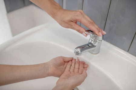 Washing hands. Close up picture of a kid washing hands in the bathroom