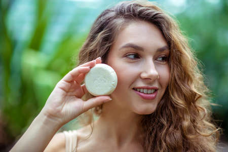 Organic. Pretty young woman with long hair holding a bar of soapの写真素材