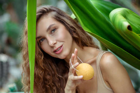 Orange soap. Beautiful woman sitting and holding a bar of orange soapの写真素材