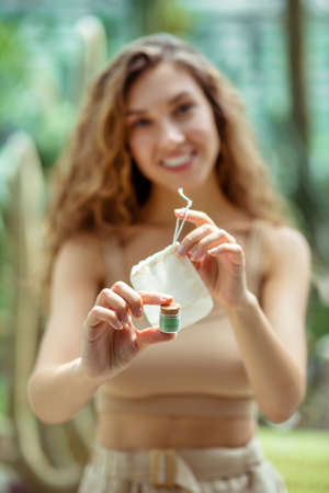 Eco cosmetics. Pretty young woman showing eyeshadow box and eco bag
