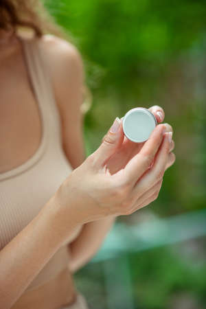 Lip balm. Close up of womns hands holding lip balmの写真素材