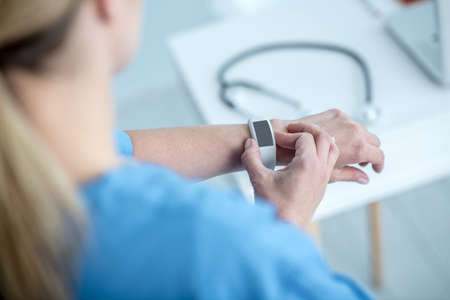 Time. Close up of a woman looking at smartwatchの写真素材