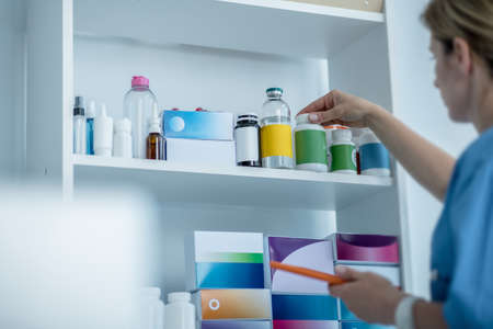 Pills. Doctor in lab coat searching for a bottle with pills