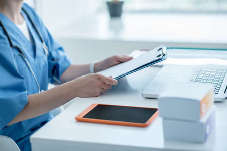 Working. Close up pictire of a woman in lab coat working in the office