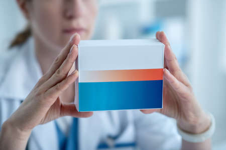 New medicine. Pharmacist in a lab coat presenting new medicineの写真素材