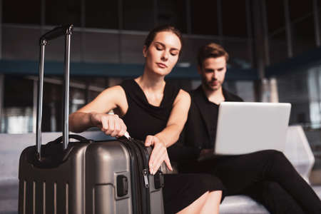 Checking necessary details. A concentrated woman opening a large brown suitcase