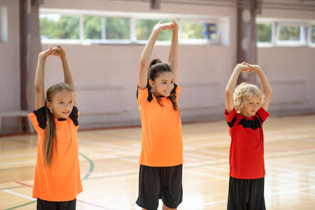 In the gym. Three kids doing stretching in the gymの写真素材