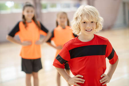 Blonde boy. Blonde boy in red tshirt standing with hands on hips