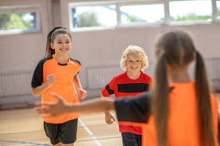 Gym time. Kids in bright sportswear feeling excited in gym