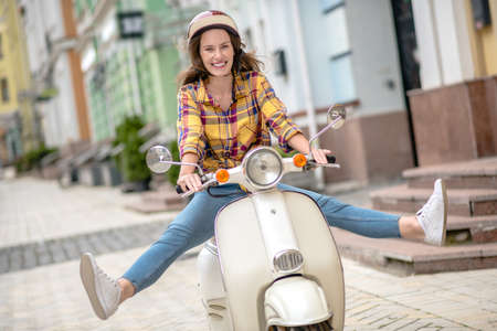 First experience. A woman trying to keep balance while driving a scooterの写真素材