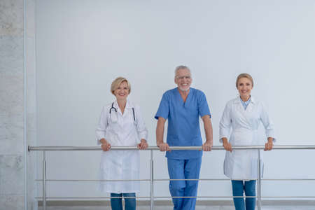 Best team. Smiling hospital team leaning on stair railingの写真素材