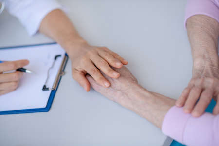 Support. Close up picture of human hands on the tableの写真素材