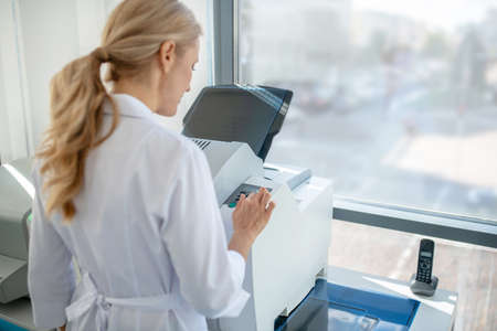 At work. Fair-haired young doctor having a busy day in clinic