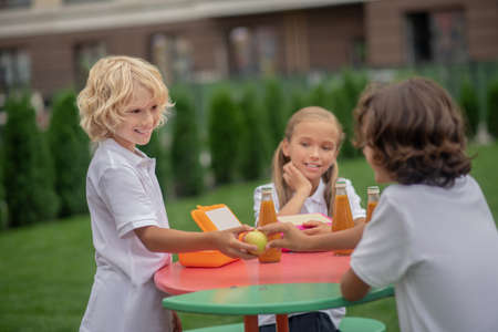 Lunch time. Children having lunch together and looking peacefulの写真素材