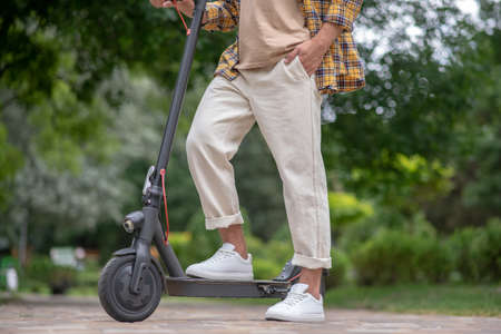 In the park. Picture of a man riding a scooter in the park