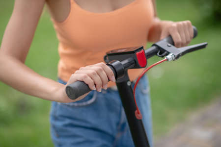 Scooter. Close up picture of womans hand holding a handlebar