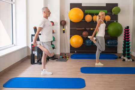 Fitness . A man and a woman in sportswear stretching their legs at fitness classの写真素材