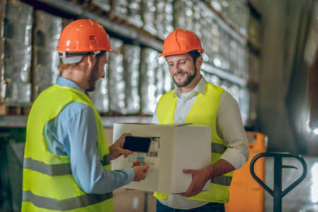 Barcodes. Two warehouse workers scanning barcodes from the containersの写真素材