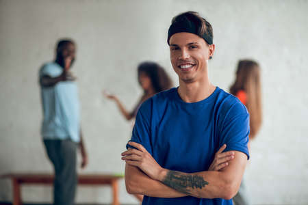 Professional. A man wearing a blue t-shirt standing in a confident pose