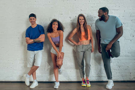 Group of people. Energetic young people standing near the wallの写真素材